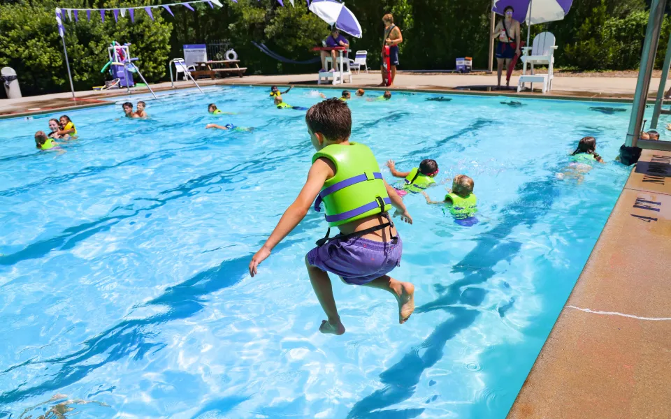 Boy jumping into a swimming pool